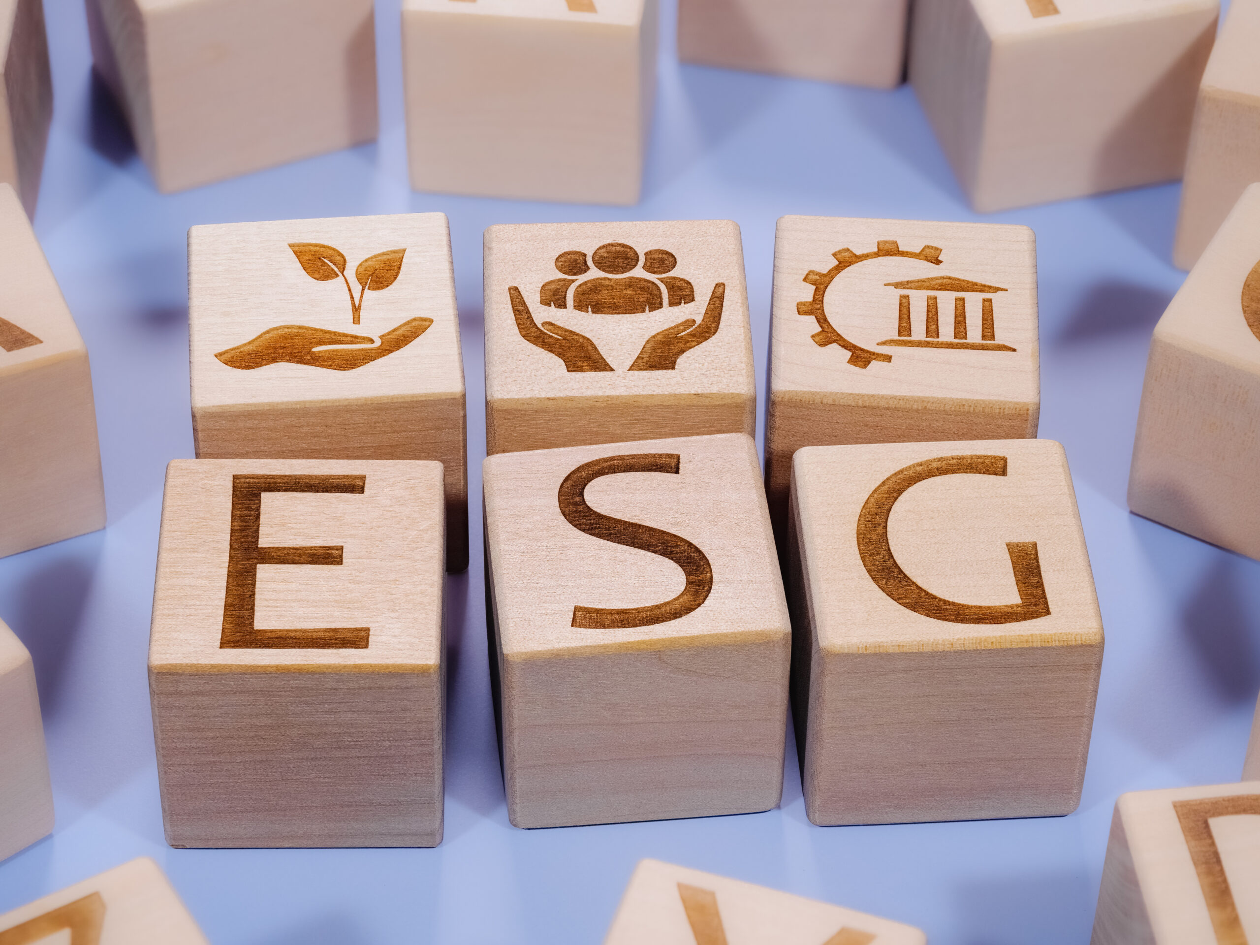 ESG concept on wood blocks among other cubes on a pink background ESG concept on wooden cubes among other cubes on a pink background